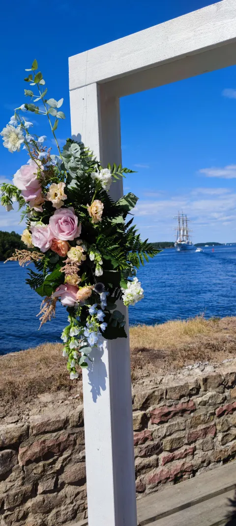 Närbild på blommor på bröllopsbåge på bryggan